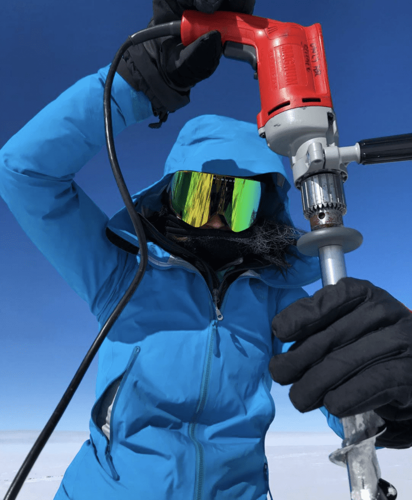 Michalea holding an auger used to drill into the snow and firn on the surface of the Greenland ice sheet, May 2019.